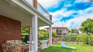 A covered patio with wicker furniture, a pool, and a brick wall. - Lovely little house a few meters from the beach of the romantic Manerba (Manerba)