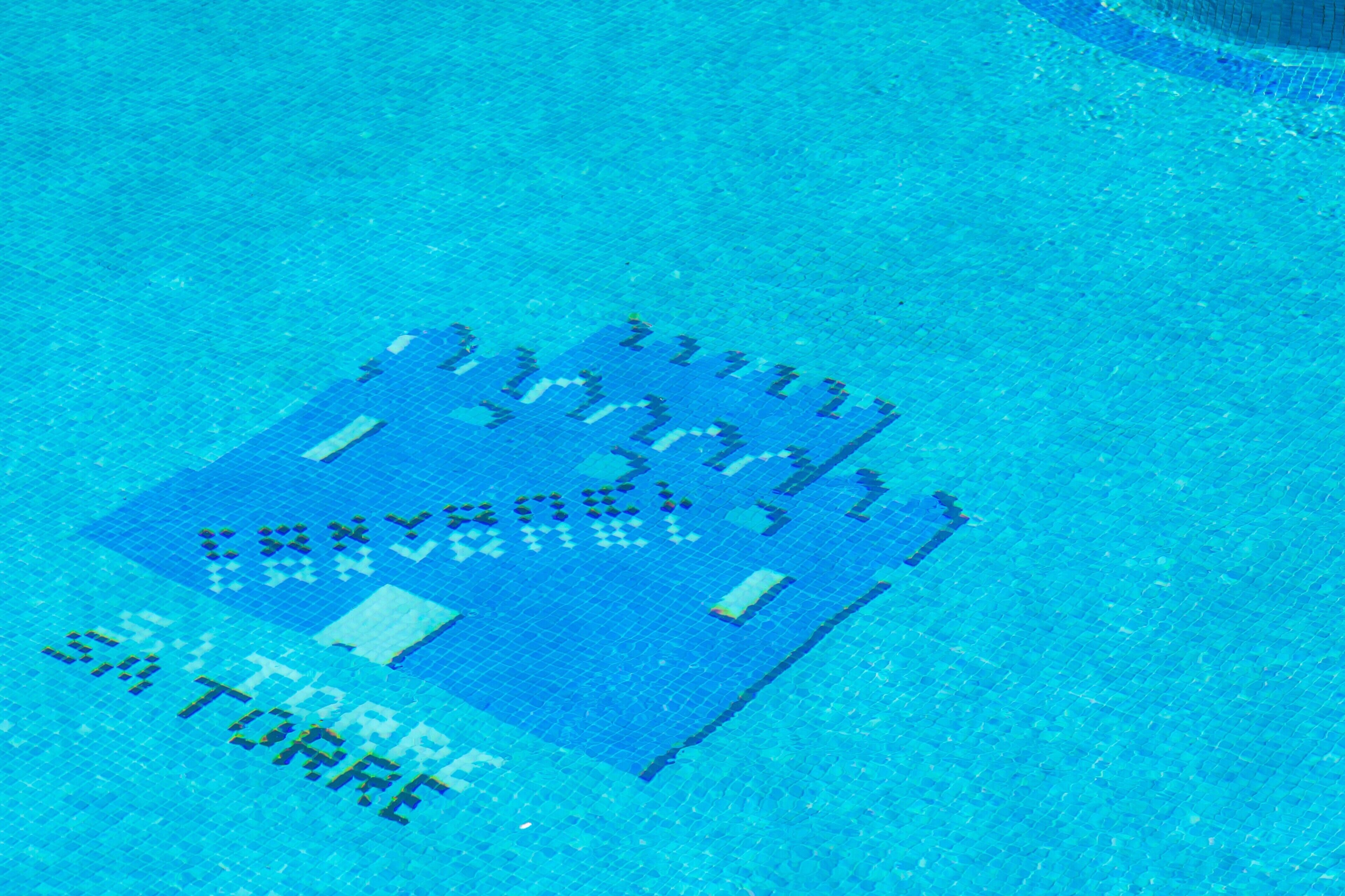 A pool with a castle-like pattern on the floor.