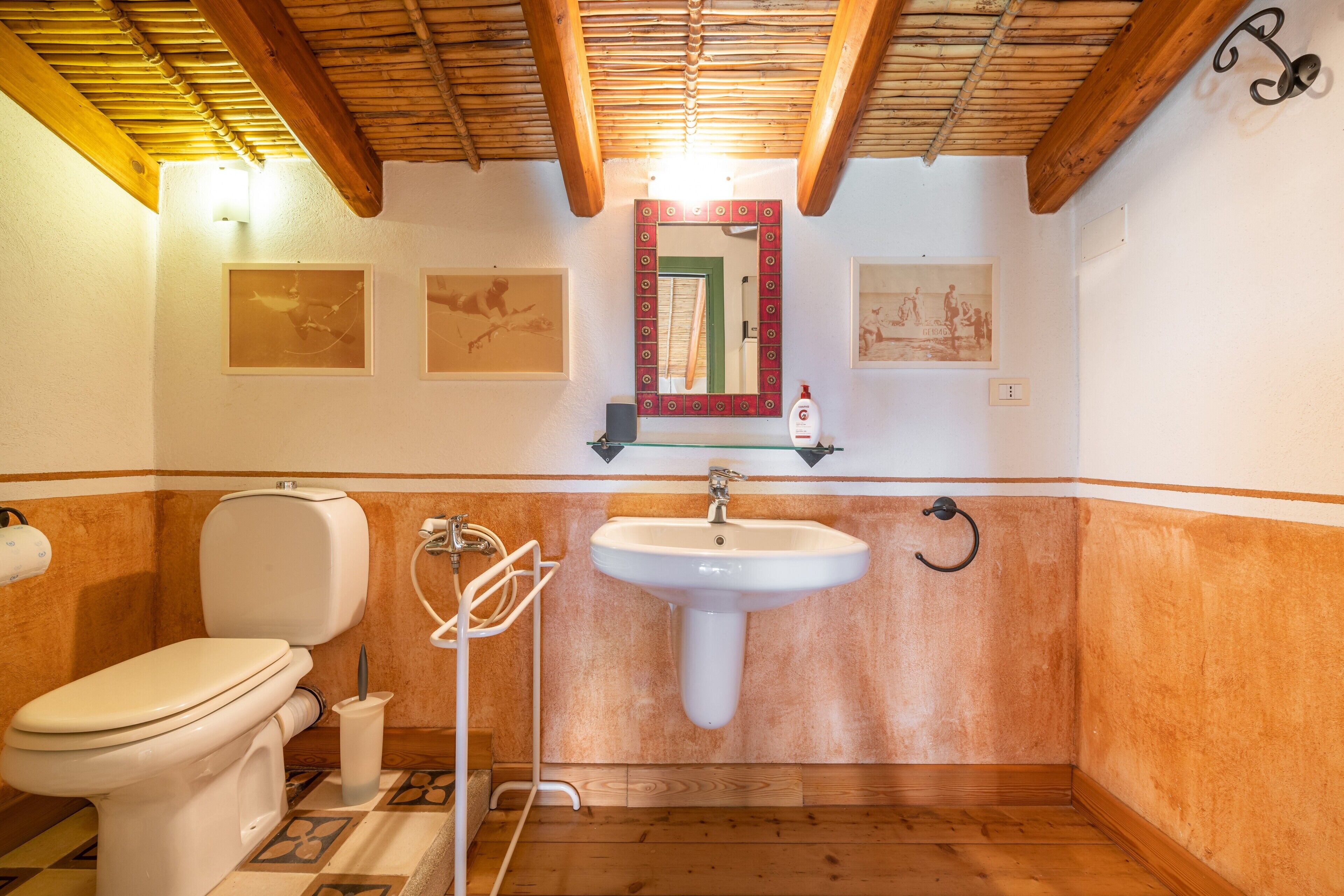 A bathroom with a toilet, sink, and shower.