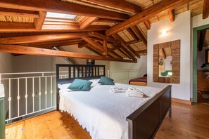 Une chambre avec un plafond en bois, un lit avec des oreillers et un miroir fixé au mur.