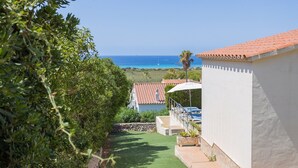 A view of a coastal property with a patio, a pool, and a clear view of the ocean. - Vacation Home "Villa Primavera" with Sea View and Pool (son bou, Alaior)