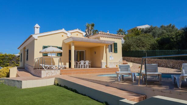 A two-story house with a swimming pool, outdoor seating, and a well-maintained lawn. - Vacation Home "Villa Llebeig" Near the Beach with Sea View and Pool (San Jaime Mediterráneo)