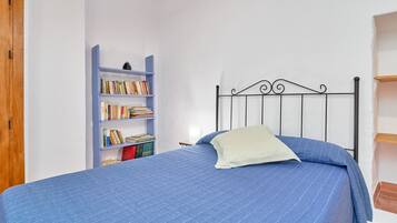 Ein Schlafzimmer mit einem Bett, einem Bücherregal und einem Holzschrank.