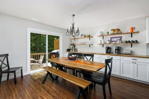 Eine moderne Küche mit weißen Schränken, Holz Arbeitsplatten und einem Essbereich mit Holztisch und Stühlen.