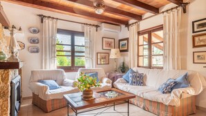 A cozy living room with two sofas, a coffee table, and a fireplace. - Villa "Can Sol" with Private Pool and Large Garden in Pollensa (Pollensa)