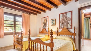 A bedroom with a wooden four-poster bed, two single beds, a large window with curtains, and artwork on the wall. - Villa "Can Sol" with Private Pool and Large Garden in Pollensa (Pollensa)