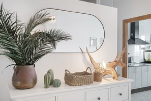A white cabinet with a potted plant, a woven basket, and a wooden sculpture. - Apartment 'Piso Amplio Y Luminoso Con Garaje' in Conil (Conil de la fra.)