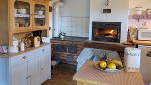 Una cocina con estufa de ladrillo, armarios de madera y salpicadero de azulejos.