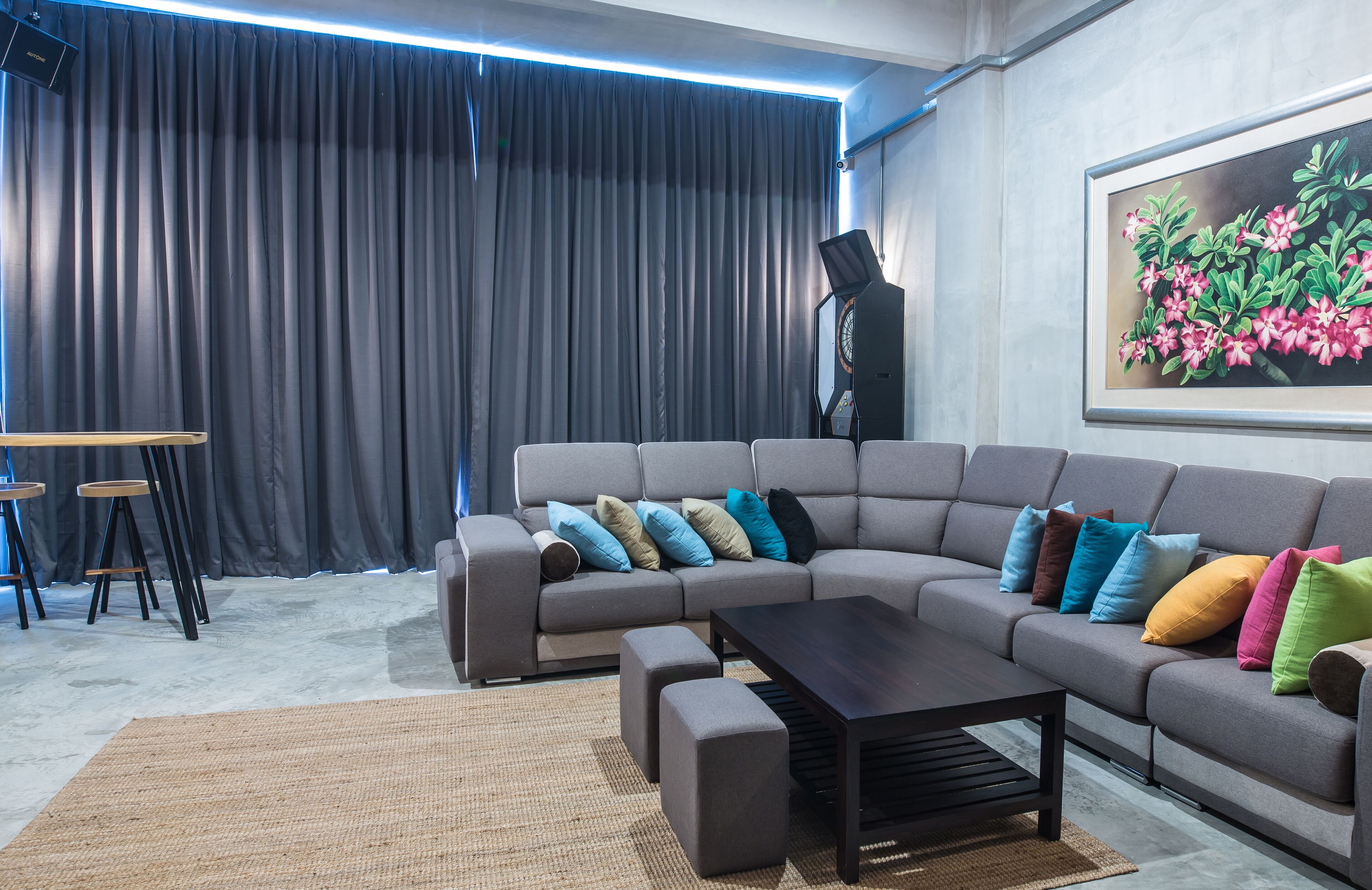 A modern living room with a sectional sofa, a coffee table, and a large painting on the wall.