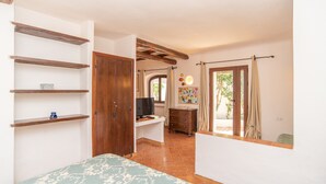 A bedroom with a bed, a desk, a TV, and a wardrobe.