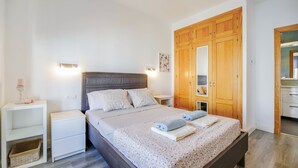 Una camera da letto con un letto, comodini, un armadio e una piccola lampada da comodino.