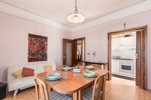 Un coin repas avec une table en bois, des chaises et un canapé blanc.
