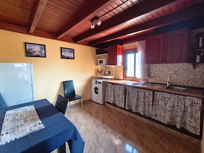 A compact kitchen with a washing machine, a microwave, and a sink.