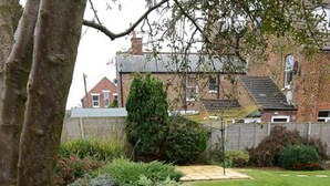 A landscaped garden with a variety of plants and a well-maintained lawn.
