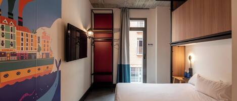 A hotel room with a bed, a TV, a wall mural, a window, and a door.