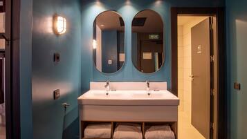 A bathroom with two sinks, a mirror, and a towel rack.