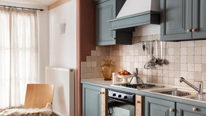 A kitchen with teal cabinets, a stove, and a sink.