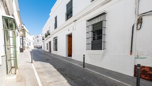 Un vicolo stretto fiancheggiato da edifici bianchi, un sentiero in pietra e un cielo azzurro intenso.