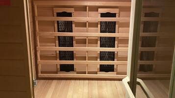 A wooden interior with a built-in heater, a ventilation system, and a shelf unit.
