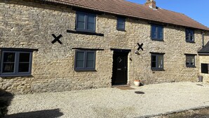 A stone building with a tiled roof, multiple windows, and a door. - The Roade House Rooms (Northampton)