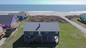 Une propriété située en bord de mer, comprenant une maison dotée d’un porche couvert et d’une petite terrasse.