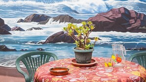 A table with a potted plant, a pitcher, and a glass with fruit. - Charming Holiday Apartment with Terrace (Barbate)