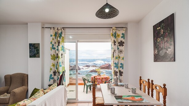 A dining area with a table, chairs, and a view of the ocean. - Charming Holiday Apartment with Terrace (Barbate)