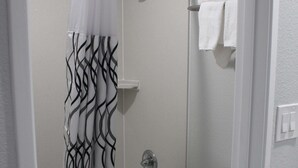 Un baño con ducha, bañera y retrete.