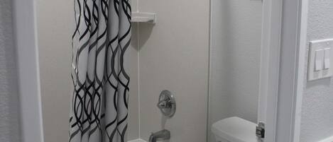 A bathroom with a shower, a bathtub, and a toilet.