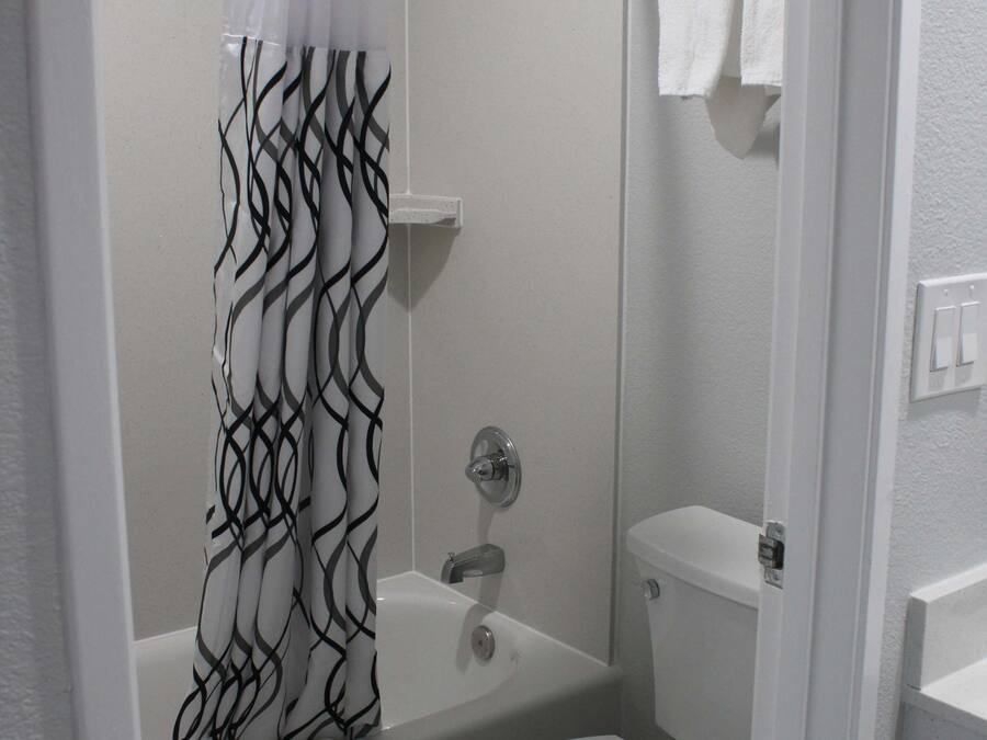 A bathroom with a shower, a bathtub, and a toilet.