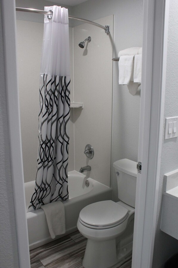 A bathroom with a shower, a bathtub, and a toilet.