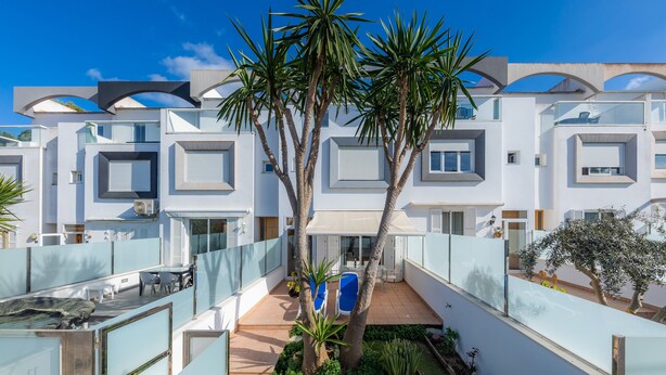 A modern building with multiple balconies, palm trees, and a clear blue sky. - Near the Beach and with Terrace - Can Bennasar (Can Picafort)