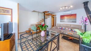 A modern living room with a glass coffee table, a sofa, a TV, and a decorative vase. - Near the Beach and with Terrace - Can Bennasar (Can Picafort)