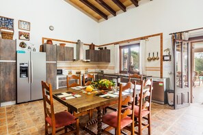Un'ampia cucina con tavolo e sedie, e un frigorifero.
