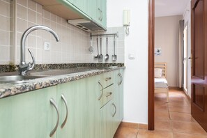 Una cucina con piano in granito, rubinetto in acciaio inossidabile e utensili appesi.