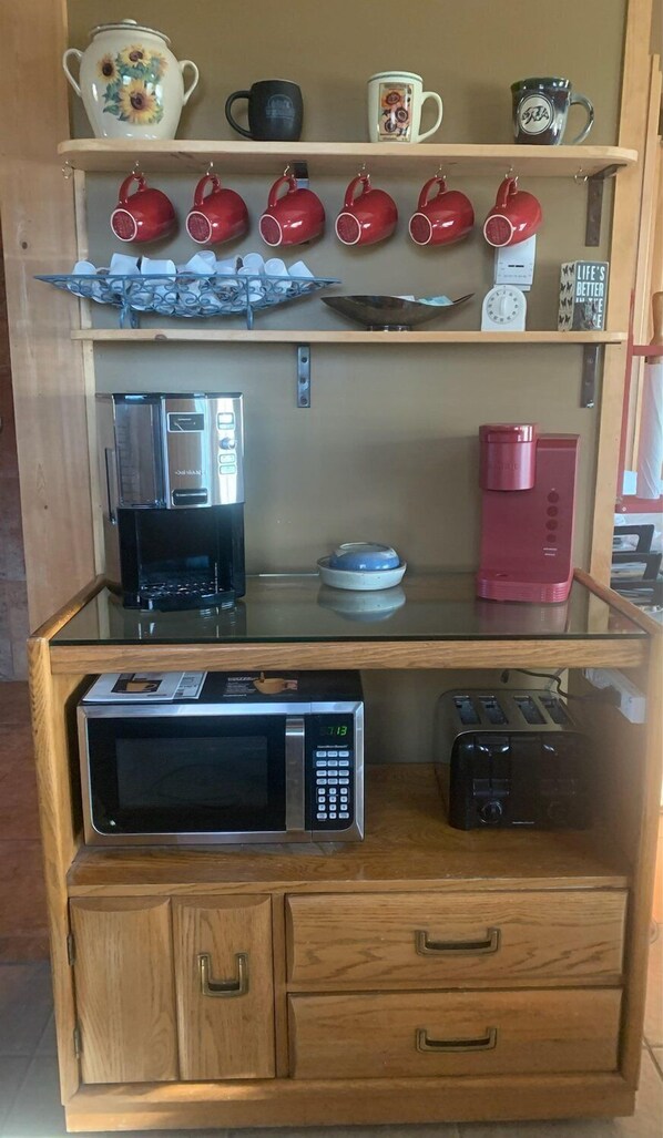 A kitchen counter with a microwave, toaster, and coffee maker. - Heart Strings Ranch- Views of Heart Mountain & Near Horses! (Cody)