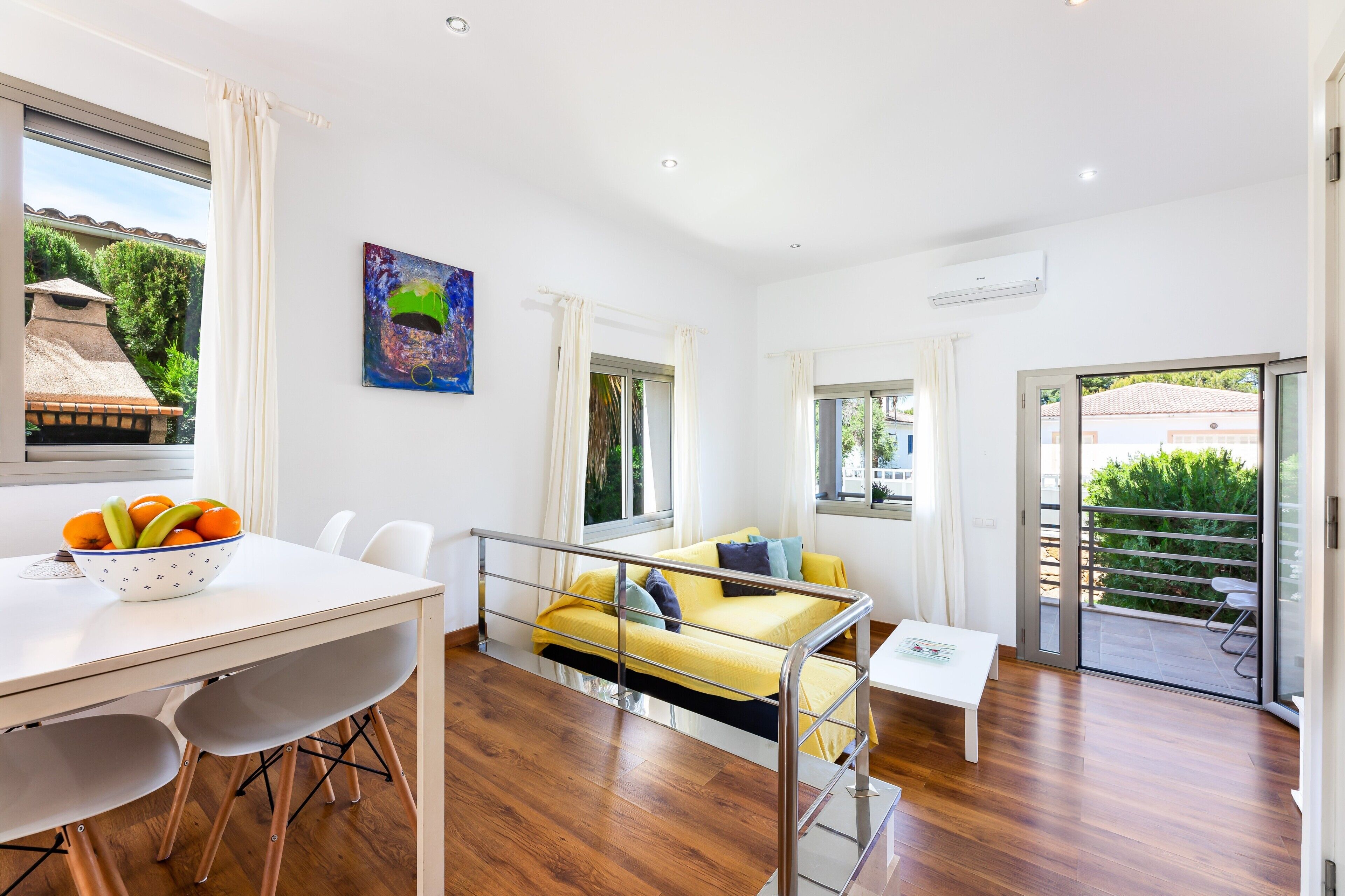 Een modern interieur met een eetgedeelte, bank en balkon.