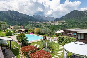 Ein Pool mit Bergblick, eine Terrassenanlage und eine Aussicht auf eine Stadt.