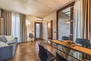 Une pièce moderne avec une table à manger en verre, un canapé et un fauteuil.