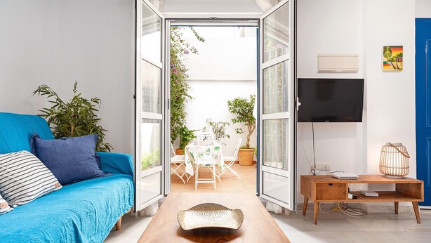 Un espace de vie à aire ouverte comprenant un canapé, une table basse en bois, un téléviseur et une table à manger avec des chaises.