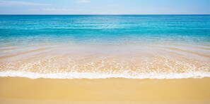 Ein Strand mit klarem türkisblauem Wasser und einem sandigen Ufer.