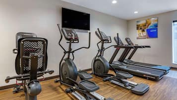 A gym with treadmills, elliptical machines, and a stationary bike.