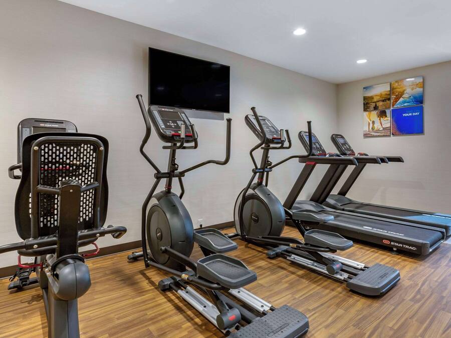 A gym with treadmills, elliptical machines, and a stationary bike.