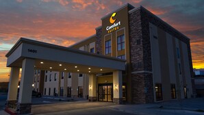 Un hotel Comfort Suites amb un disseny modern, que destaca per la seva entrada ben visible i un cel clar al fons.