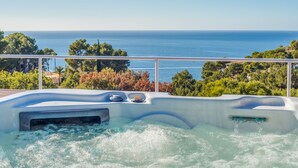 A hot tub with a view of the sea and trees. - Air-Conditioned Villa with Sea View, Pool, Jacuzzi, Rooftop Gym/Terrace & Wi-Fi (Costa De La Calma, CALVIÀ)