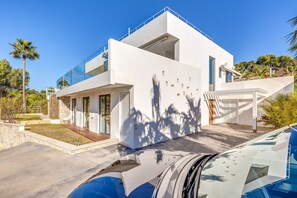 A modern two-story house with a garage, a swimming pool, and a clear blue sky.