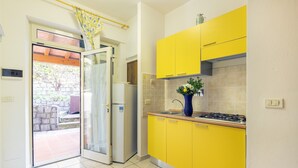 Una cocina con armarios amarillos, una estufa a gas y una puerta que da a un patio.