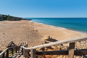 A beach with a wooden staircase leading down to the sand, a clear blue sky, and calm sea. - Exclusive villa with garden and pool - Villa con encanto (Roche)