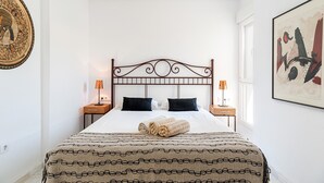 A neatly arranged bedroom with a bed, two bedside tables, and a window.