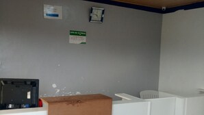 Una habitación con un escritorio blanco, un reloj y un cartel en la pared.